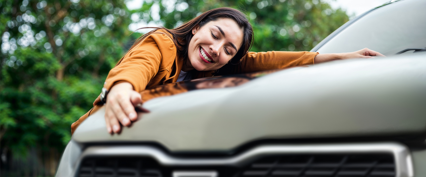 Glückliche Kundin umarmt ihr Auto